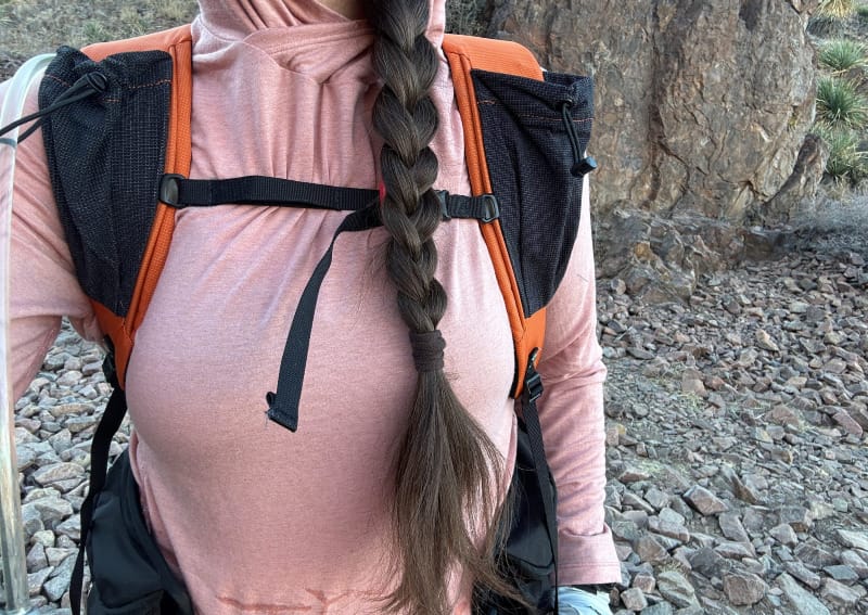a woman shows the sternum strap on the Wy'east Daypack By Six Moon Designs and fit