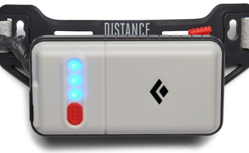 Close-up of the Black Diamond Distance 1500 headlamp rear battery pack with LED charge indicators and head strap.