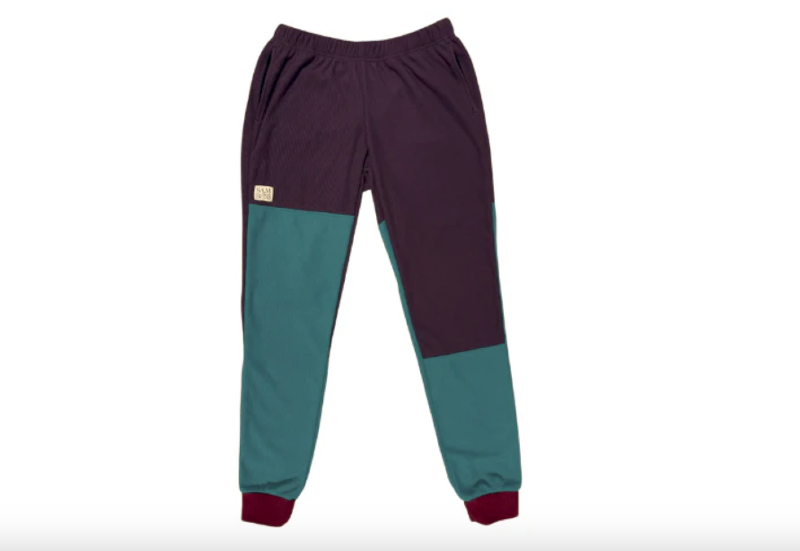 Flat lay of SAMBOB Microgrid fleece jogger pants in color-blocked eggplant and teal with cuffed ankles and elastic waistband.