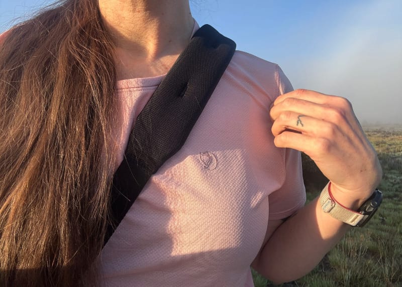 Close-up of a woman wearing the Fjallraven Abisko Lite SS Top in light pink, showing the breathable, lightweight fabric and logo detail.