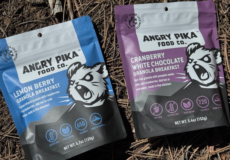  Angry Pika Food Co. Lemon Berry and Cranberry White Chocolate granola breakfast pouches placed side by side on forest floor.