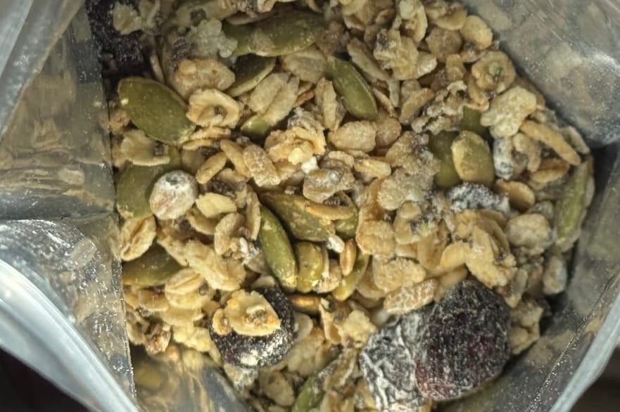  Open pouch of Angry Pika Chocolate Strawberry granola showing oats, pumpkin seeds, and dried fruit.