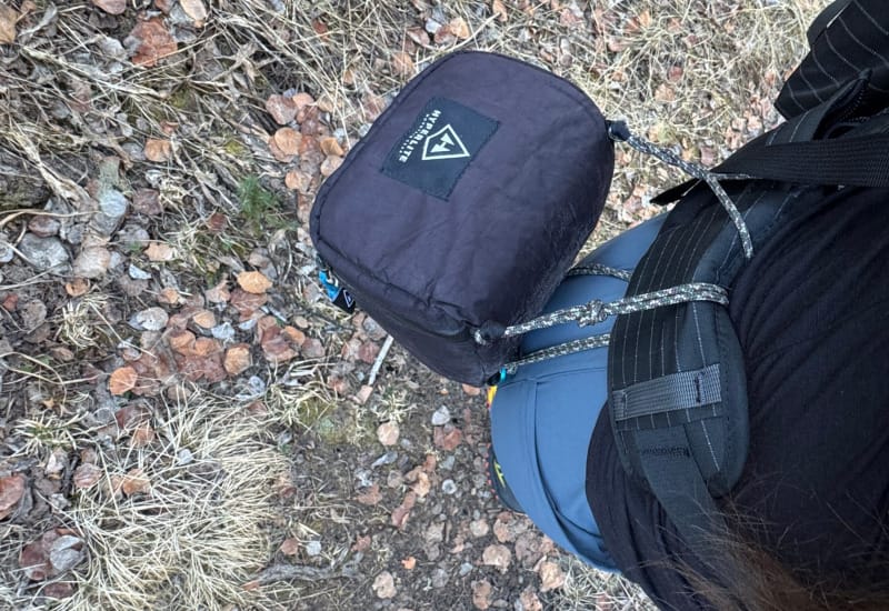 Black Hyperlite Camera Pod mounted on a backpack hipbelt during a hike