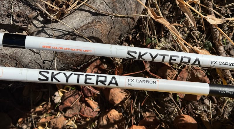 LEKI Skytera FX Carbon SL trekking poles shown close-up on forest ground, highlighting their minimalist white carbon shaft.