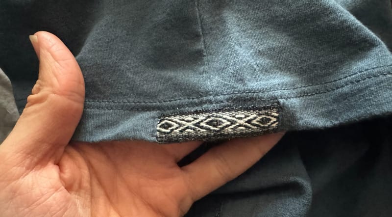 Close-up of the woven trim on the PAKA Essential Tee’s hem