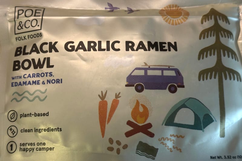  Front of the Poe & Co Black Garlic Ramen Bowl package showing playful camping-themed illustrations and ingredients list.
