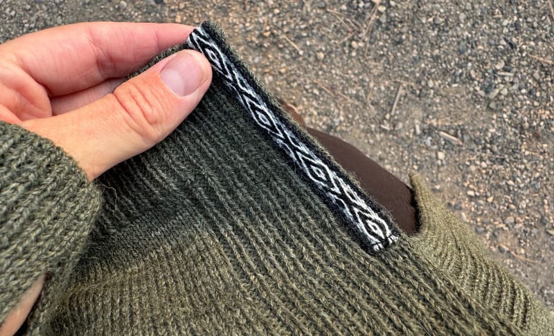 Close-up of the PAKA Women’s Hoodie hem showing decorative Andean-inspired woven detail.