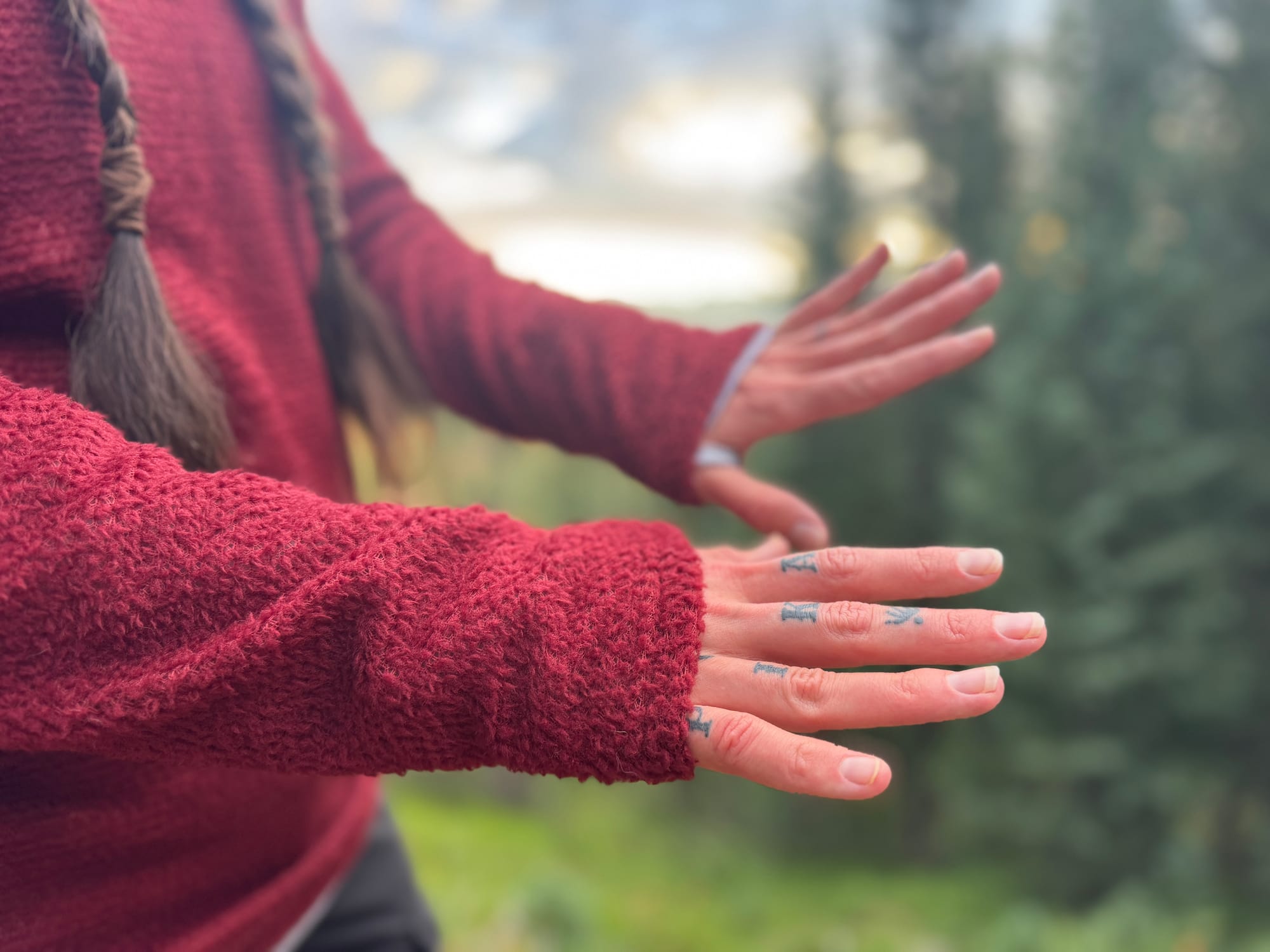 Close-up of a hiker’s hands and sleeves while wearing the FarPointe Alpha Cruiser, highlighting thumb loops and fleece texture.