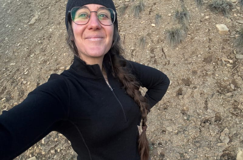 Person wearing the Arms of Andes Alpaca Wool Half-Zip Base Layer outdoors during a cold mountain hike, showcasing fit and layering versatility.