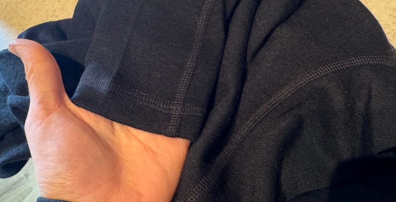 Close-up of the Arms of Andes Alpaca Wool Half-Zip Base Layer fabric and collar texture, showing smooth natural alpaca fibers and stitching details.