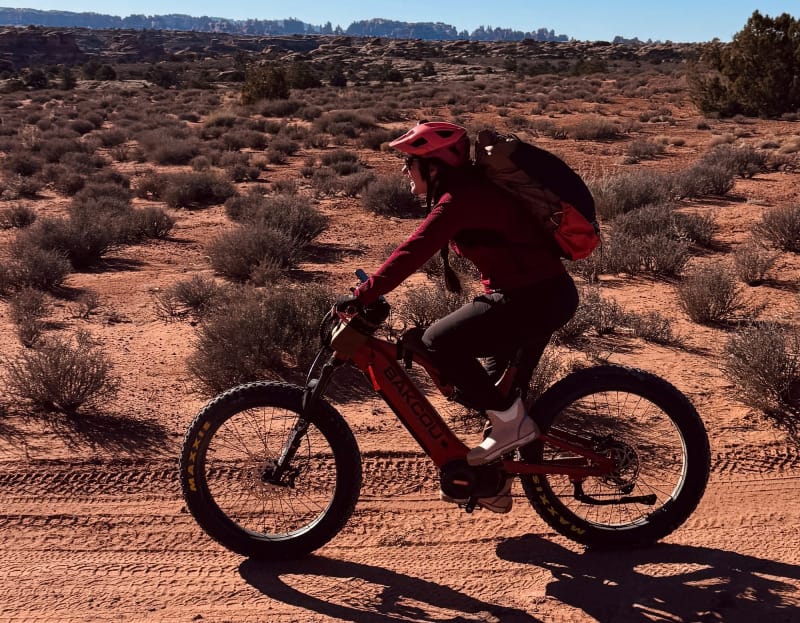 Person riding a Bakcou E-Moto Puma X22 SD during the 2025 Holiday Sale event, with 10% off Black Friday deal and buy-one-get-one offer on Badger Scooter.