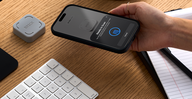 Close-up of hiker using the Brick device to disable smartphone apps before starting a hike, symbolizing distraction-free hiking and digital mindfulness.