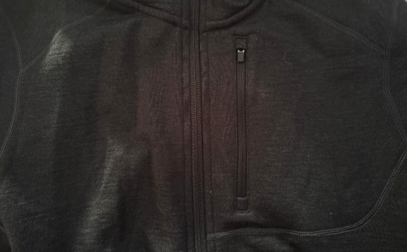 Close-up of zippered pocket on Ibex Mammoth Full-Zip Hoodie, showing sleek black merino fabric.