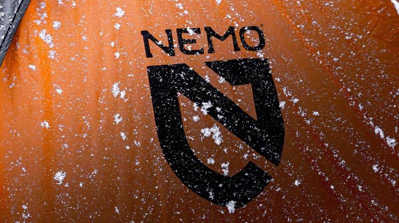 Close-up of NEMO Kunai Tent orange sailcloth with snow, designed for 4-season backpacking durability.