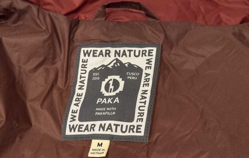 Interior tag of PAKA Mayu Ultralight Jacket showing Wear Nature label and PAKAFILL insulation details.