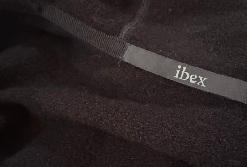 Close-up of Ibex Mammoth Full-Zip Hoodie fabric tag showing size and brand logo.