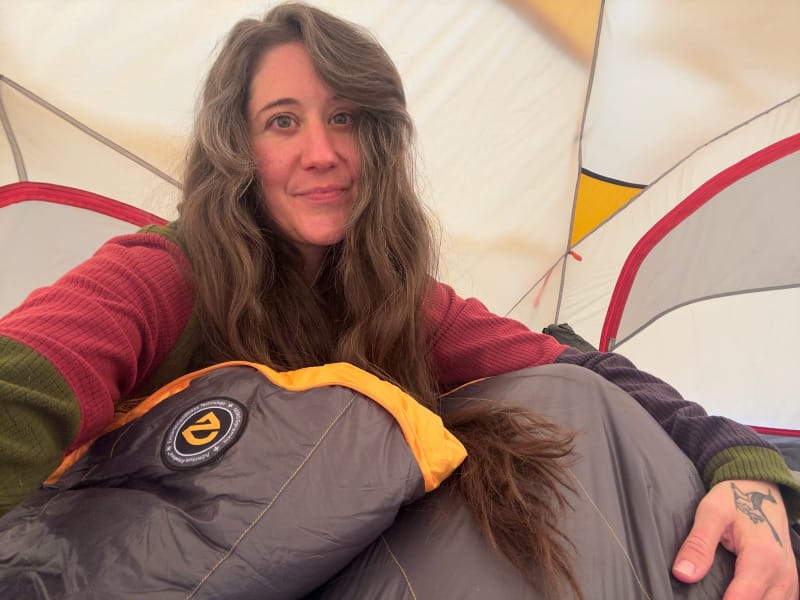 Person inside NEMO Kunai 4-Season Tent with sleeping bag, showing interior space and comfort for backpacking.