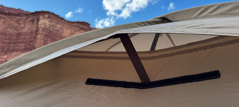 Close-up of Snow Peak Minute Dome Pro Air 1 tent ventilation flap under the fly with desert cliffs in background.