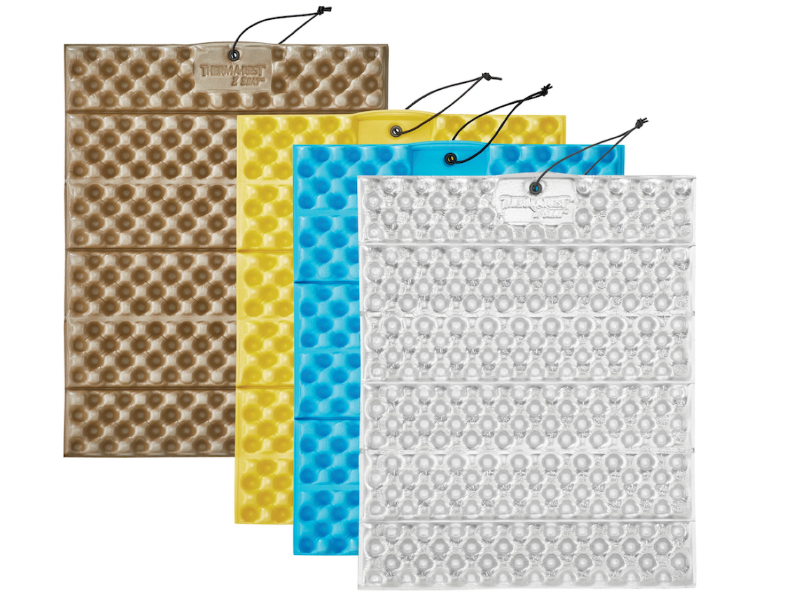 Therm-a-Rest Z Seat foam pads in assorted colors, compact and portable for hiking or backpacking.