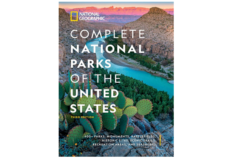Cover of the book Complete National Parks of the United States showing a desert canyon landscape with cactus and a river below.
