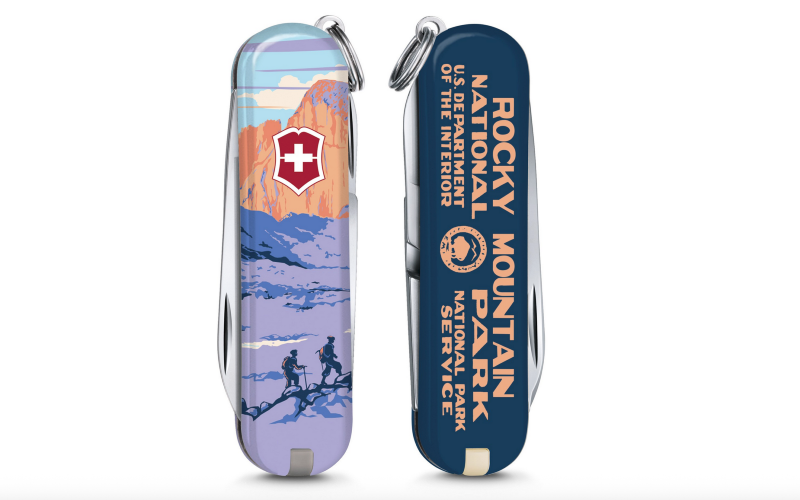 Swiss Army knife with illustrated Rocky Mountain National Park graphics showing hikers and mountain scenery.
