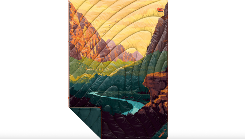 Rumpl puffy blanket showing a colorful illustrated landscape of Zion National Park with cliffs and a winding river.