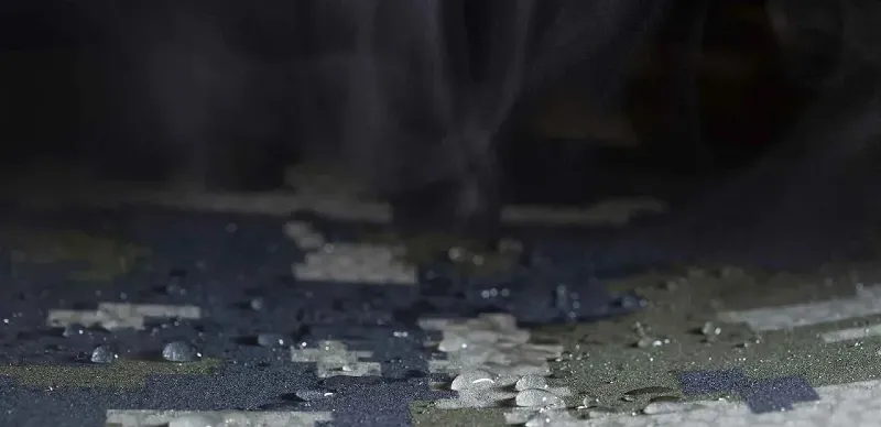 Close-up of water beading on the surface of the KUIU Super Down Pro Glomitts, demonstrating the glove’s durable water-repellent finish and weather-resistant performance.