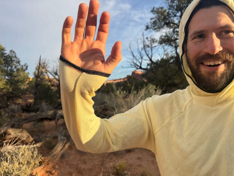 Man wearing a yellow FarPointe Sun Cruiser showing thumbhole cuffs and hood while hiking in the desert.