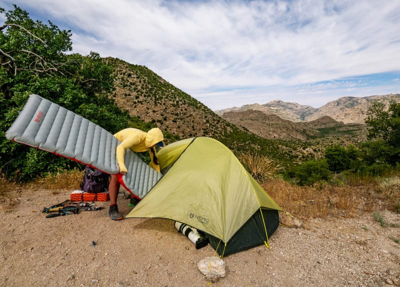 Semi freestanding ultralight solo backpacking tent set up in desert mountain terrain with rocky ground