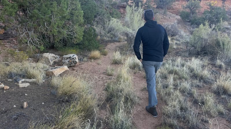 back view of hiker walking on desert trail wearing Outdoor Vitals Pursuit Hybrid Fleece during outdoor hike