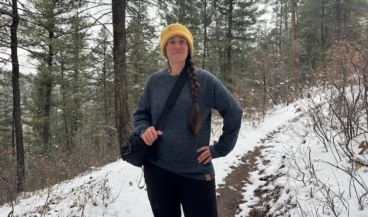 A woman wearing PAKA's The Original Crew on a hike in snow.
