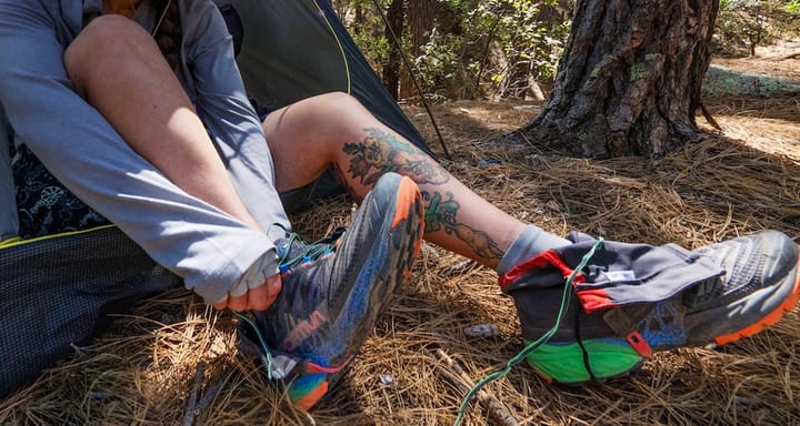 a camper putting on her Kahtoola RENAgaiter Low Ultra-Tough Gaiters