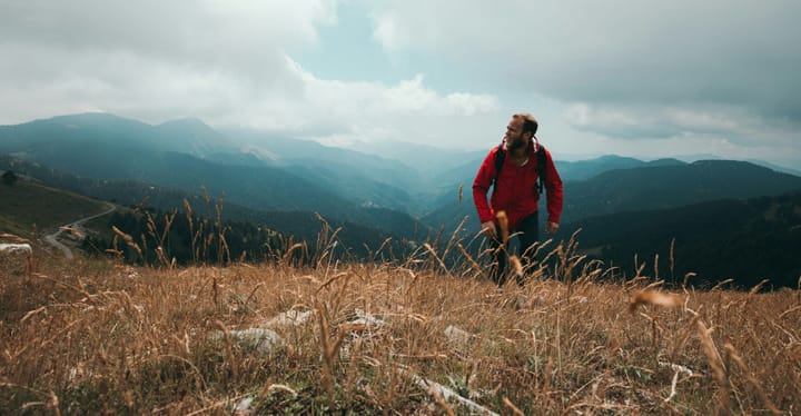 a man in a hike in a beautiful mountain lanscape. he is wearing one of out picks for top daypack of 2025.