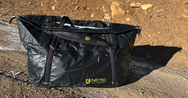 Double Haul 100 Liter Convertible Duffel & Tote By NEMO Equipment sitting outside in the mountains for car camping