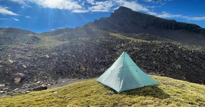 Hyperlite Mountain Gear tent pitched in a remote mountain landscape, showcasing ultralight backpacking shelter design.