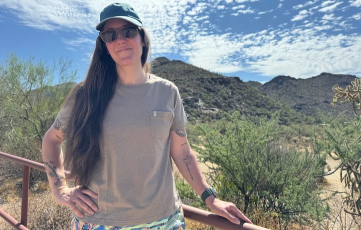  Person wearing the Paka Pocket Tee outdoors in the desert, standing in front of mountains and blue sky, showcasing the shirt’s fit and comfort.