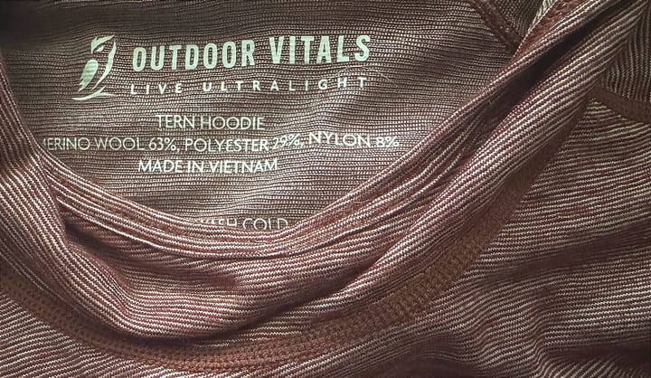 Close-up of the Tern Hoodie by Outdoor Vitals showing the interior label and wool-polyester fabric blend.