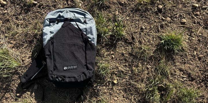 Gossamer Gear Cima 15 backpack on the ground, highlighting its compact design and front mesh pocket.