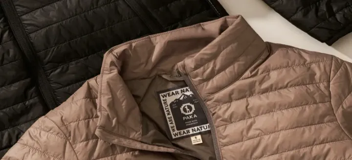 Close-up of PAKA Mayu Ultralight jackets and vests in black, maroon, and tan, featuring lightweight design and sustainable PAKAFILL® alpaca insulation.