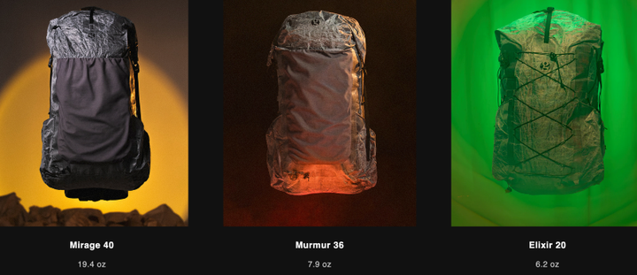 Three Gossamer Gear Alchemy backpacks displayed with dramatic lighting: the Mirage 40 illuminated in yellow, Murmur 36 in red, and Elixir 20 in green