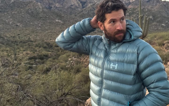 Himali Accelerator Down Jacket worn outdoors in a desert mountain landscape during a cold-weather hike